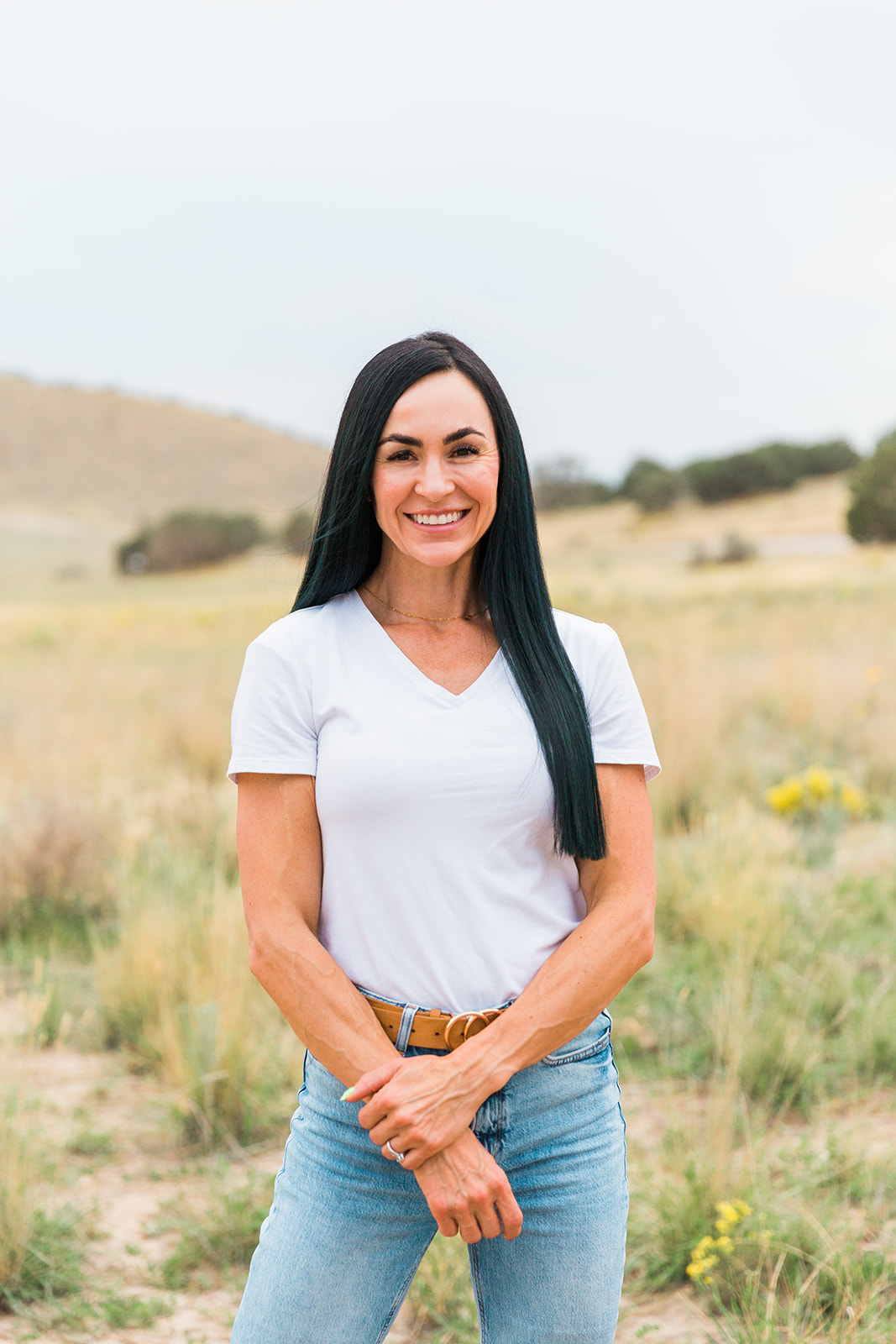 Val standing in an open field, smiling
